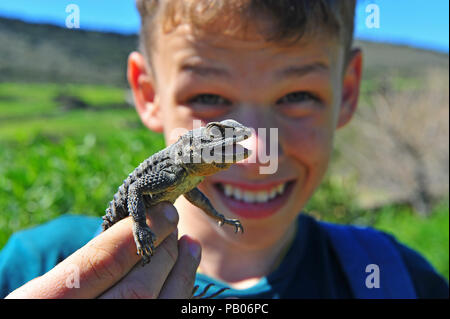 Happy boy with lizard in his hands outdoors Stock Photo