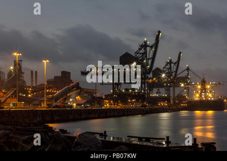 Industrial port coal and iron ore transport ship at an Australian Port on dark wet stormy night Stock Photo