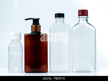 Empty plastic and glass bottle with cap and pump with black label isolated on white background. Pharmaceutical products bottle packaging. Stock Photo