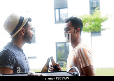 Two men making a celebratory toast at a barbecue Stock Photo