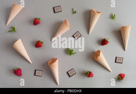 Top view of empty ice cream cones with fresh ingredients including strawberries, mint and chocolate Stock Photo