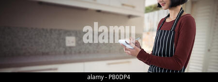 Composite image of smiling waitress writing order on notepad Stock Photo