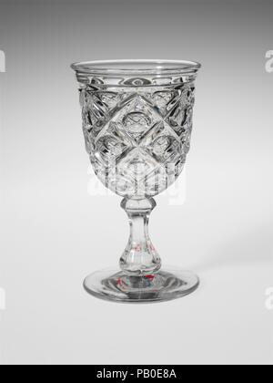 Goblet. Culture: American. Dimensions: H. 6 7/16 in. (16.4 cm); Diam. 3 5/16 in. (8.4 cm). Date: 1850-60.  With the development of new formulas and techniques, glass-pressing technology had improved markedly by the late 1840s. By this time, pressed tablewares were being produced in large matching sets and innumerable forms. During the mid-1850s, colorless glass and simple geometric patterns dominated. Catering to the demand for moderately-priced dining wares, the glass industry in the United States expanded widely, and numerous factories supplied less expensive pressed glassware to the growing Stock Photo