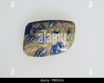 Glass mosaic bowl fragment. Culture: Roman. Dimensions: 1 1/4 × 1 13/16 × 1/8 in. (3.1 × 4.6 × 0.3 cm)  Estimated diameter: 3 1/8 in. (8 cm). Date: late 1st century B.C.-early 1st century A.D..  Translucent cobalt blue, opaque white, and colorless with bluish tinge.  Vertical rim with flat lip; almost vertical side, sloping gently inwards, then curved sharply in to bottom.  Composite mosaic pattern formed from sections of a single cane in a colorless ground with irregular white rods surrounding a blue circle dotted with white rods. A wide blue network cane would spirally with a white thread is Stock Photo