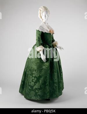 Ensemble. Culture: American. Date: ca. 1775.  This dress is considerably less gaudy than continental and English clothing of the period. Yet, it is not lacking in sumptuousness. Rather, the green Spitalfields damask, attributed to Anna Maria Garthwaite about 1743-45, is richly displayed. The Costume Institute acquired this dress in 1994, knowing that it would be in the Museum's exhibition 'John Singleton Copley's America.' It has since appeared in our show 'The Ceaseless Century.' One could argue that the relative simplicity engenders more delight in the dress's inherent voluptuousness. Genera Stock Photo