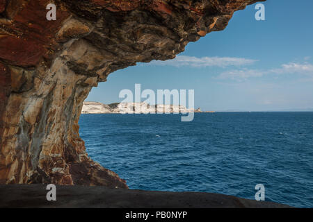 View of the white cliffs of Bonifacio and the coast of Sardinia from a World War 2 lookout cut into the rock above the Mediterranean sea in southern C Stock Photo