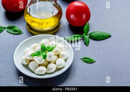 Mozzarella, red tomatoes and fresh Basil on a black background. top view. Flat lay. Food concept. Healthy and wholesome food Stock Photo