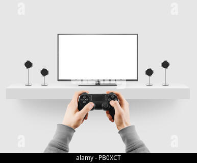 Man hold gamepad in hands in front of blank tv screen mock up playing game. Clear monitor mockup with gamer first person. Video gaiming console screen Stock Photo