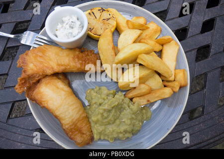 Hotel Lunch fish of the day two battered lemon sole fillets with chunky chipped potatoes mushy peas and tartare sauce Stock Photo