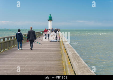 Calais, France - 19 June 2018: Walkers and fishermen on the west jetty in the summertime. Stock Photo