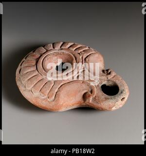 Terracotta oil lamp. Culture: Roman, Egyptian. Dimensions: Overall: 1 x 3 1/16 in. (2.5 x 7.8 cm). Date: 2nd-early 3rd century A.D..  With palmette shaped design and maker's mark, 'I'. Museum: Metropolitan Museum of Art, New York, USA. Stock Photo
