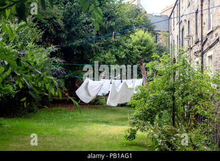 Clothes are hanging out to dry on a line in a tenement garden in Stockbridge, Edinburgh, Scotland, UK. Stock Photo
