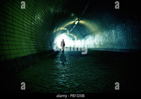 man walking under a tunnel toward the exit - image for book cover