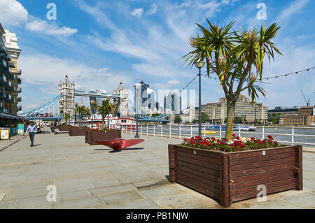 The newly pedestrianised riverside area behind Butlers Wharf buildings on the South Bank of the Thames, looking towards Tower Bridge, London UK Stock Photo