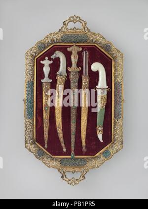 Tray of Jeweled Daggers. Culture: Turkish. Dimensions: L. 31 3/8 in. (79.7 cm); W. 18 1/2 in. (47 cm). Date: probably late 19th century.  This opulent array of daggers belongs to a large group of flamboyant gem-studded weapons that were probably made in Istanbul in the waning years of the Ottoman Empire. Their traditional shapes and luxurious materials were intended to evoke romantic notions of  the exotic orient, <i>Arabian Nights</i>, or perhaps the sultan's treasury. As most of these weapons are found today in American and European collections rather than in Turkish museums, they may have b Stock Photo