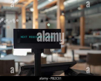 Cash register in airy eatery displaying next register please sign Stock Photo