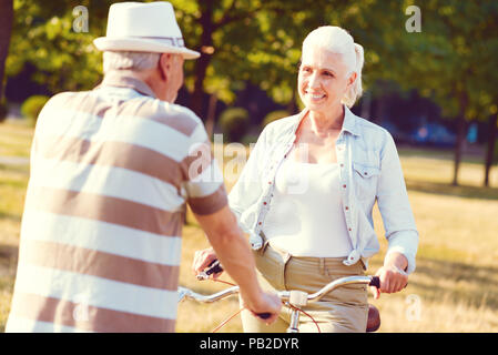 Joyful couple talking while sitting on bicycles Stock Photo