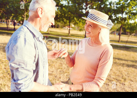 Adorable elderly couple dancing in park Stock Photo