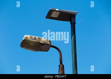 Street lamp head / light / lights / lamps of an older sodium technology (left) which are in the process of being replaced by LEDs / LED (right). (100) Stock Photo