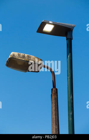 Street lamp head / light / lights / lamps of an older sodium technology (left) which are in the process of being replaced by LEDs / LED (right). (100) Stock Photo