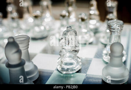 Glass chess pieces on a glass chessboard Stock Photo