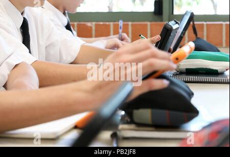 High school students working on using an ipad tablet style electronic computer device. modern pedagogy and teaching learning in education educational Stock Photo