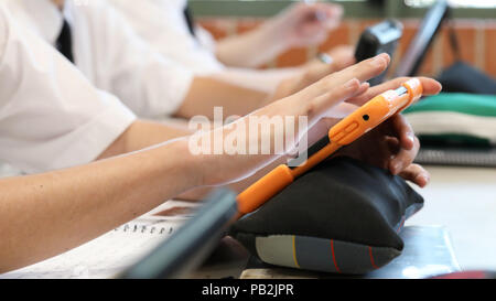 High school students working on using an ipad tablet style electronic computer device. modern pedagogy and teaching learning in education educational Stock Photo