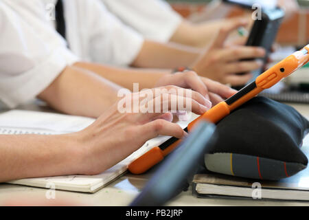 High school students working on using an ipad tablet style electronic computer device. modern pedagogy and teaching learning in education educational Stock Photo