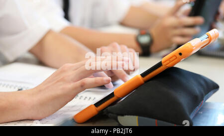 High school students working on using an ipad tablet style electronic computer device. modern pedagogy and teaching learning in education educational Stock Photo
