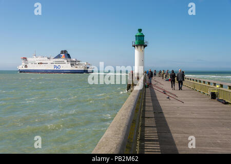 Calais, France - 19 June 2018: People on the west jetty and cross Channel P&O ferry leaving the port. Stock Photo