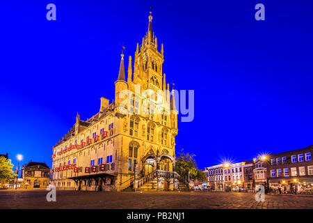 Monumental gothic City hall of the historical city Gouda square, illuminated with lights during dusk under a dark blue sky. One of the oldest Gothic c Stock Photo