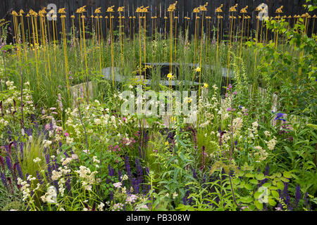 Beautiful show garden (natural planting, colourful meadow flowers, tractor sculpture) - John Deere Garden, RHS Chatsworth Flower Show, England, UK.