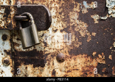 Old and rusty metal door has been locked long time ago Stock Photo