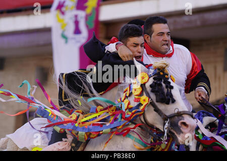 Carpio Tajo, Toledo, Spain. 25th July, 2018. Galloping horse riders seen clasping one another during the festival.The St. James Festival in the village of El Carpio de Tajo near Toledo, Spain. The event involves horsemen galloping towards geese suspended by their feet as the mounted participant yanks on the bird's neck until it is torn off. Credit: Manu Reino/SOPA Images/ZUMA Wire/Alamy Live News Stock Photo