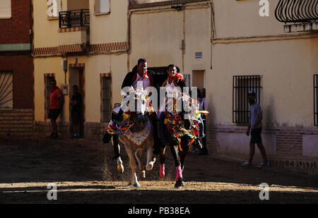 Carpio Tajo, Toledo, Spain. 25th July, 2018. Galloping horse riders seen clasping one another during the festival.The St. James Festival in the village of El Carpio de Tajo near Toledo, Spain. The event involves horsemen galloping towards geese suspended by their feet as the mounted participant yanks on the bird's neck until it is torn off. Credit: Manu Reino/SOPA Images/ZUMA Wire/Alamy Live News Stock Photo