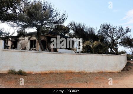 Athens, Greece. 25th July, 2018. A view of a burned out building following a wildfire north of Athens.The aftermath of the destruction by the forest fires in Mati and Neos Voutsas regions of Attiki with more than 80 dead and an unimaginable destruction of property. Credit: Helen Paroglou/SOPA Images/ZUMA Wire/Alamy Live News Stock Photo