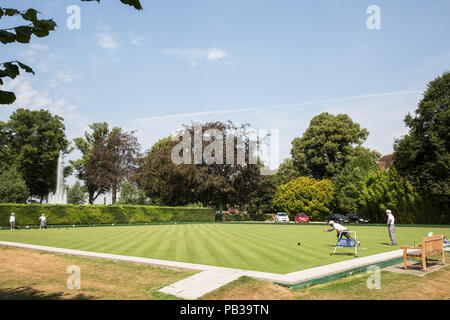 Windsor, UK. 26th July, 2018. Men and women enjoy a game of bowls on a still pristine lawn at the Windsor and Eton Bowling Club on a very hot summer's day. Temperatures are expected to reach 36C today in the south-east. Even if imposed, sports facilities such as bowling clubs are often exempt from water restrictions during a drought. Credit: Mark Kerrison/Alamy Live News Stock Photo