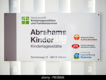 Gifhorn, Germany. 26th July, 2018. A sign is attached to the entrance of the Christian-Muslim kindergarten 'Abrahams Kinder' (lit.' Abraham's children'). Behind the new project stand the Muslim DITIB mosque, the Catholic St. Altfrid parish and the Protestant foundation Diakonie. Credit: Hauke-Christian Dittrich/dpa/Alamy Live News Stock Photo