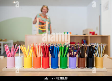 Gifhorn, Germany. 26th July, 2018. Pens in various colours are standing on a table at the opening of the Christian-Muslim kindergarten 'Abrahams Kinder' (lit.' Abraham's children'). Behind the new project stand the Muslim DITIB mosque, the Catholic St. Altfrid parish and the Protestant foundation Diakonie. Credit: Hauke-Christian Dittrich/dpa/Alamy Live News Stock Photo