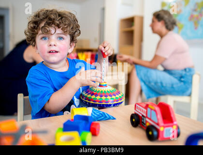 Gifhorn, Germany. 26th July, 2018. Baran plays at a table at the opening of the Christian-Muslim kindergarten 'Abrahams Kinder' (lit.' Abraham's children'). Behind the new project stand the Muslim DITIB mosque, the Catholic St. Altfrid parish and the Protestant foundation Diakonie. Credit: Hauke-Christian Dittrich/dpa/Alamy Live News Stock Photo