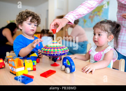 Gifhorn, Germany. 26th July, 2018. Baran (l) and Hira play at a table at the opening of the Christian-Muslim kindergarten 'Abrahams Kinder' (lit.' Abraham's children'). Behind the new project stand the Muslim DITIB mosque, the Catholic St. Altfrid parish and the Protestant foundation Diakonie. Credit: Hauke-Christian Dittrich/dpa/Alamy Live News Stock Photo