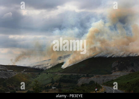 Llangollen, Denbighshire, UK. 26th July, 2018. A large smoke is seen coming out of the Mountains.Firefighters battled to put out a mountain Fire on hillside above the Horseshoe Pass in North east wales. There has been many recent outbreaks caused by a combination of extreme heatwave weather conditions and the criminal acts of arsonists. Credit: Andrew Mccoy/SOPA Images/ZUMA Wire/Alamy Live News Stock Photo