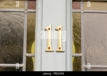 House number 11 sign on wooden door Stock Photo