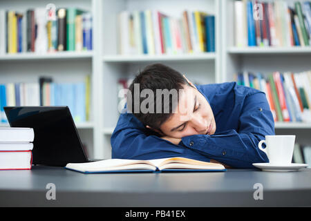 Tired student fell asleep while learning in library. Stock Photo