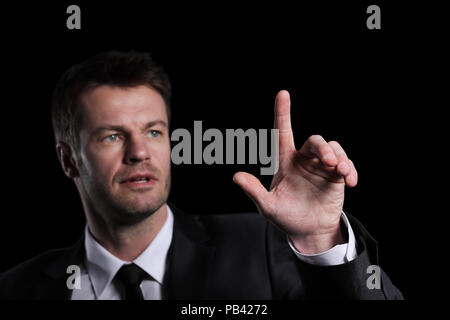 Business man pushing the imaginary  button. Isoladed on black. Stock Photo