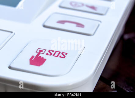 sos Red button on a dirty old panel, selective focus Stock Photo