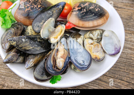 Raw seafood mollusks on wooden table Stock Photo
