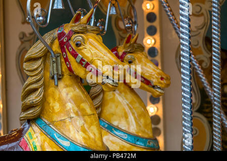 A close up of 2 Traditional style merry go round ride ride on horses. Stock Photo