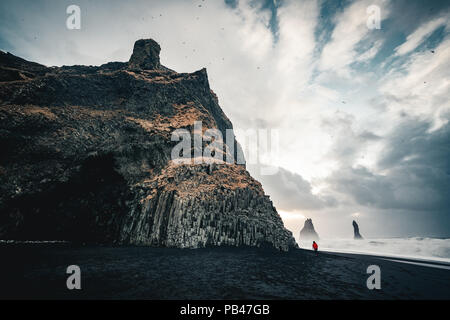 The black sand beach of Reynisfjara and the mount Reynisfjall, Iceland. Windy Morning. Ocean Waves. Colorful Sky. Morning Sunset.