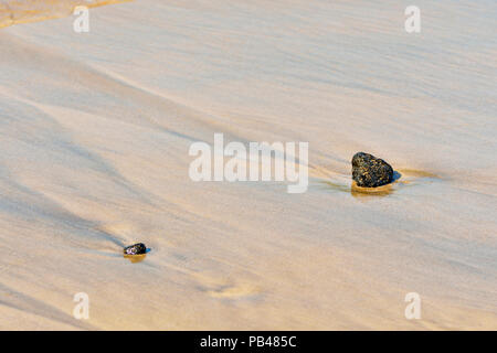 Beach stones and runoff patterns on Punta Cormorant beach, Galapagos Islands National Park, Floreana Island, Ecuador Stock Photo